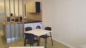En kompakt bolig med tekøkken, spiseplads og separat opholdsområde.
