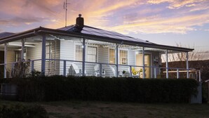 A house with a covered porch, a chimney, and a satellite dish.