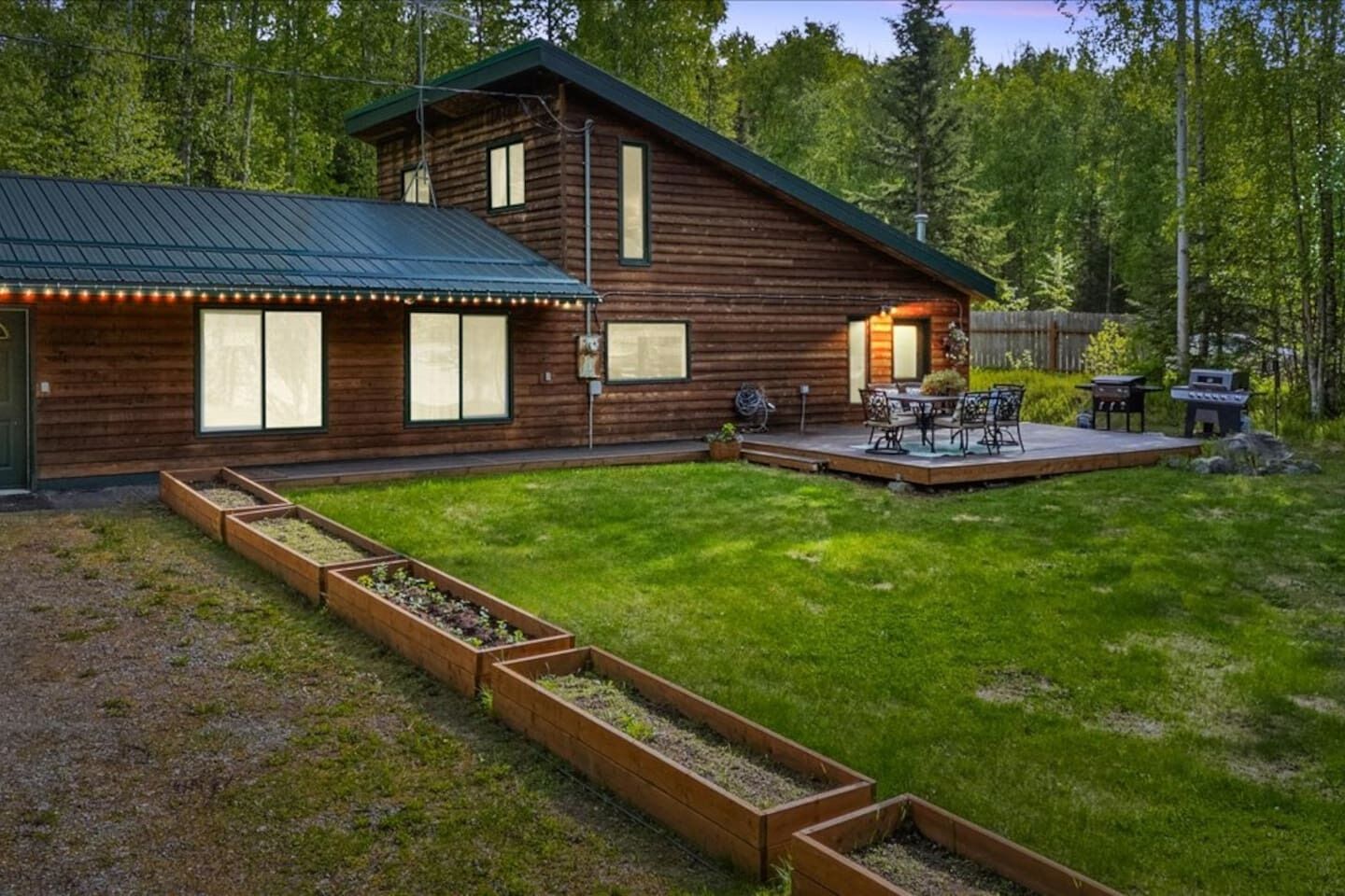 Eine Holzhütte mit einer Terrasse und einer Sitzgelegenheit im Freien.
