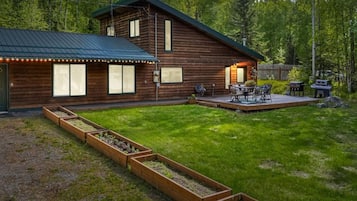 Eine Holzhütte mit einer Terrasse und einer Sitzgelegenheit im Freien.