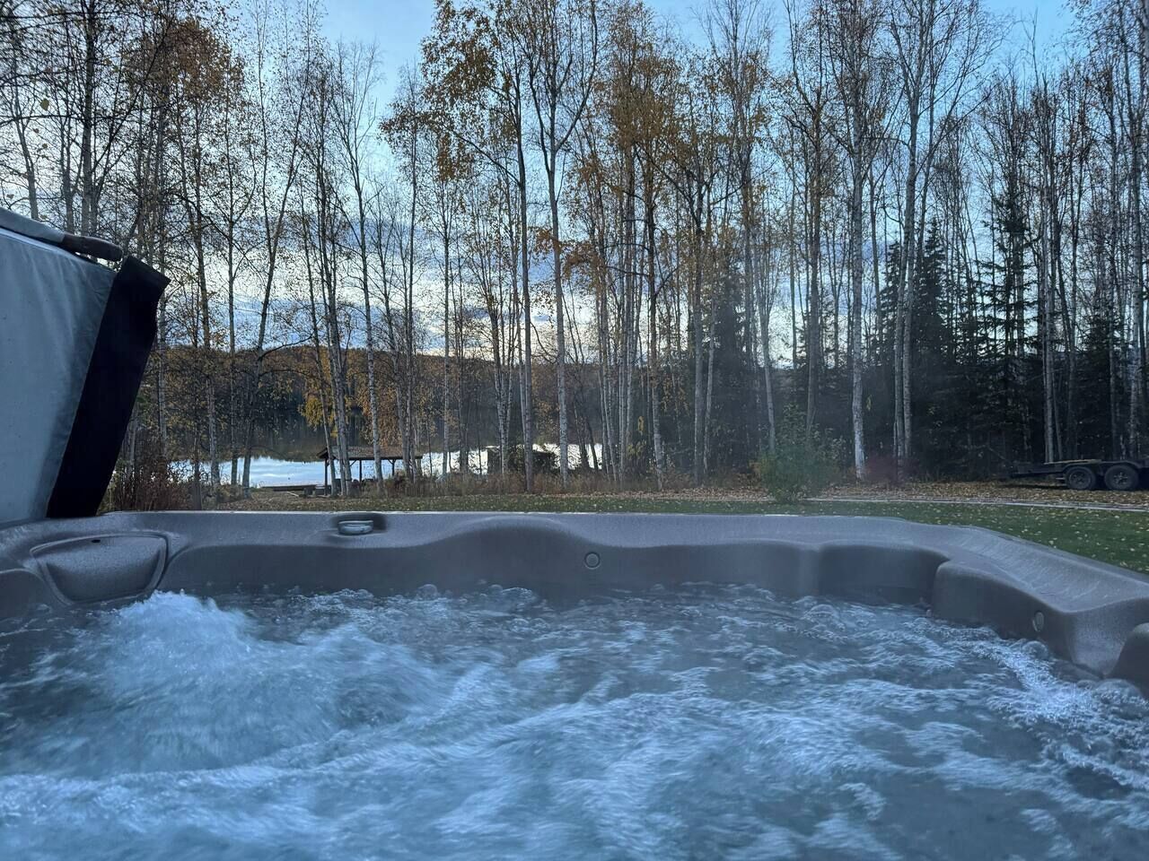 Ein Whirlpool mit Blick auf einen Wald und einen See.