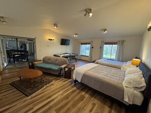 A room with two beds, a sofa, a pool table, and a dining area. - Cozy Lakefront Retreat (Wasilla)