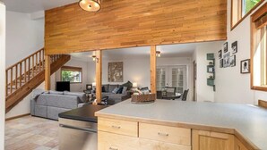 Une cuisine spacieuse dotée de meubles en bois, d’un îlot central et d’un coin repas avec une table et des chaises.