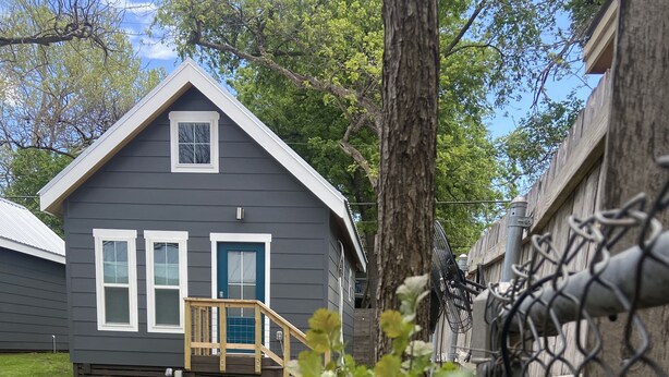 A residential house with a front porch and a wooden staircase leading to the door. - Clean, modern guesthouse located in a central Austin. (Austin)