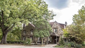 A stone building with multiple windows and a covered entrance, surrounded by trees and a paved area. - Eagle Lake Cabin Coalmont (Coalmont)