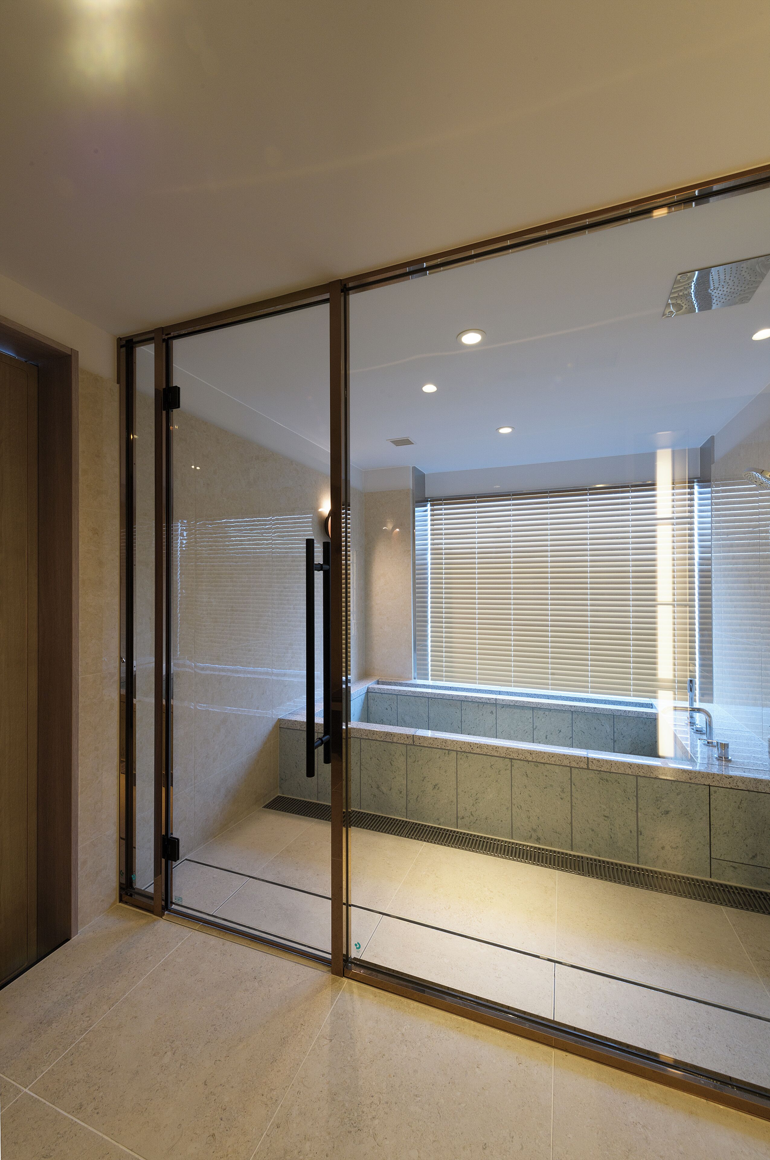 A modern bathroom with a glass partition, a bathtub, and a shower area.