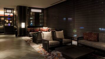 A modern lounge area with a sofa set, a coffee table, and a patterned rug.