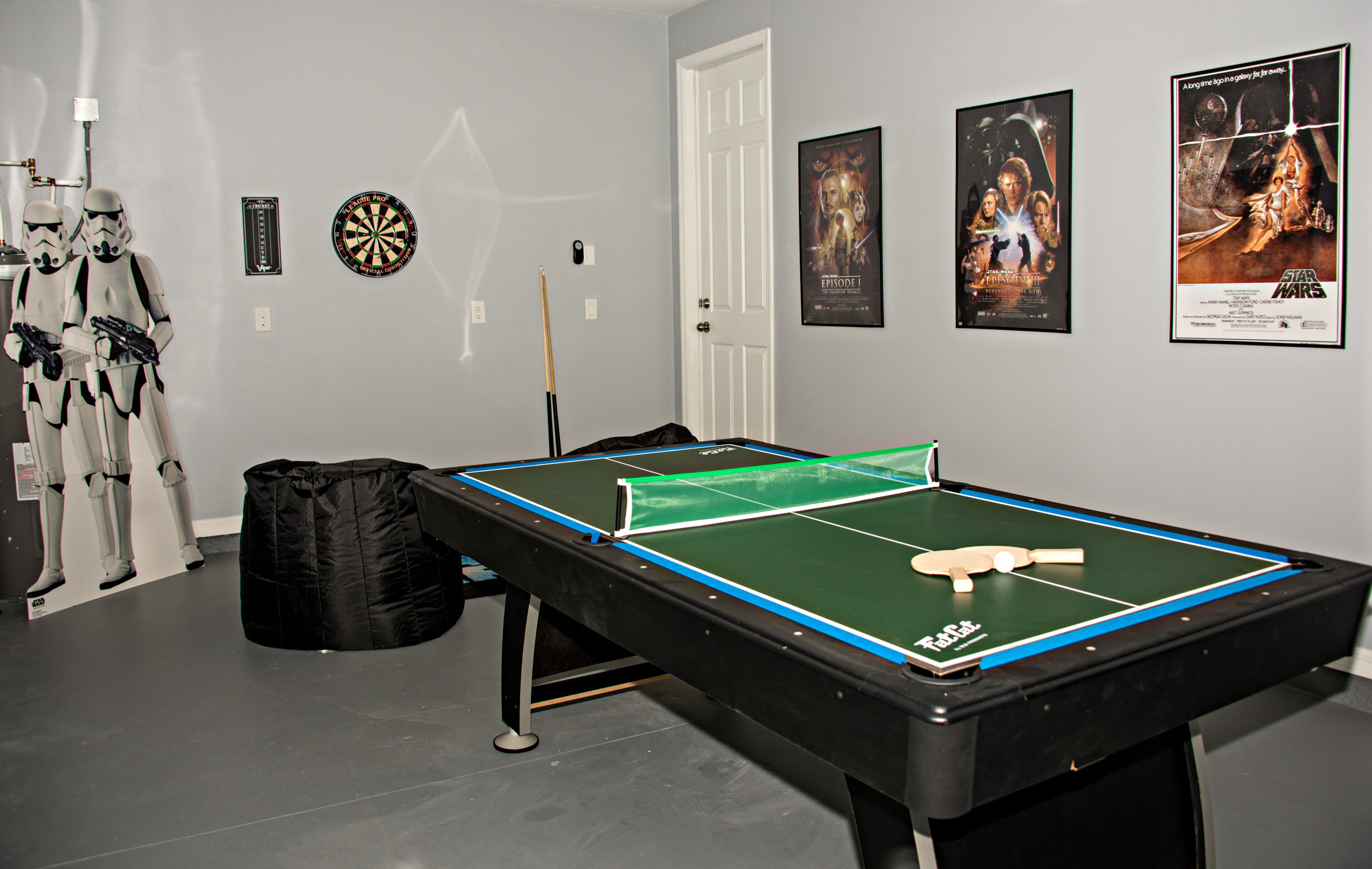 A room with a foosball table, Star Wars decorations, and movie posters on the wall.