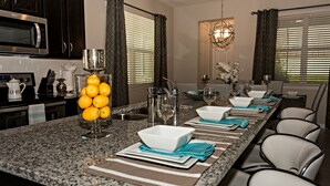 A kitchen with a granite countertop, a coffee maker, and a bowl of oranges. - Close to the Disney park! Family-sized house with Pool!!! (Kissimmee)