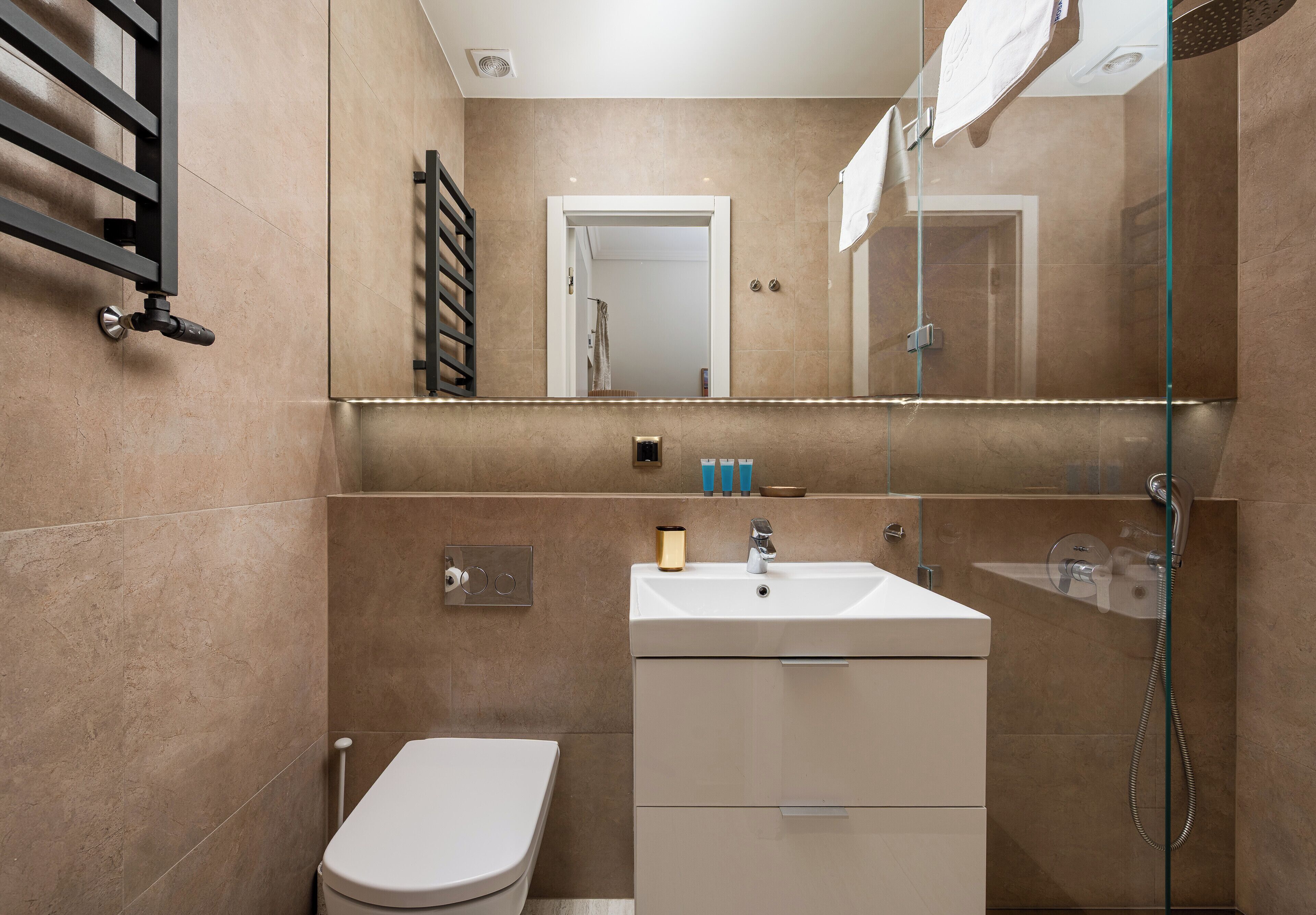 Une salle de bain moderne équipée de toilettes, d’un lavabo et d’une douche.