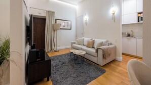 Un salon moderne avec un canapé, une table basse et un téléviseur.