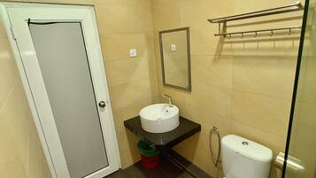 Un baño pequeño con inodoro blanco, lavamanos y espejo.