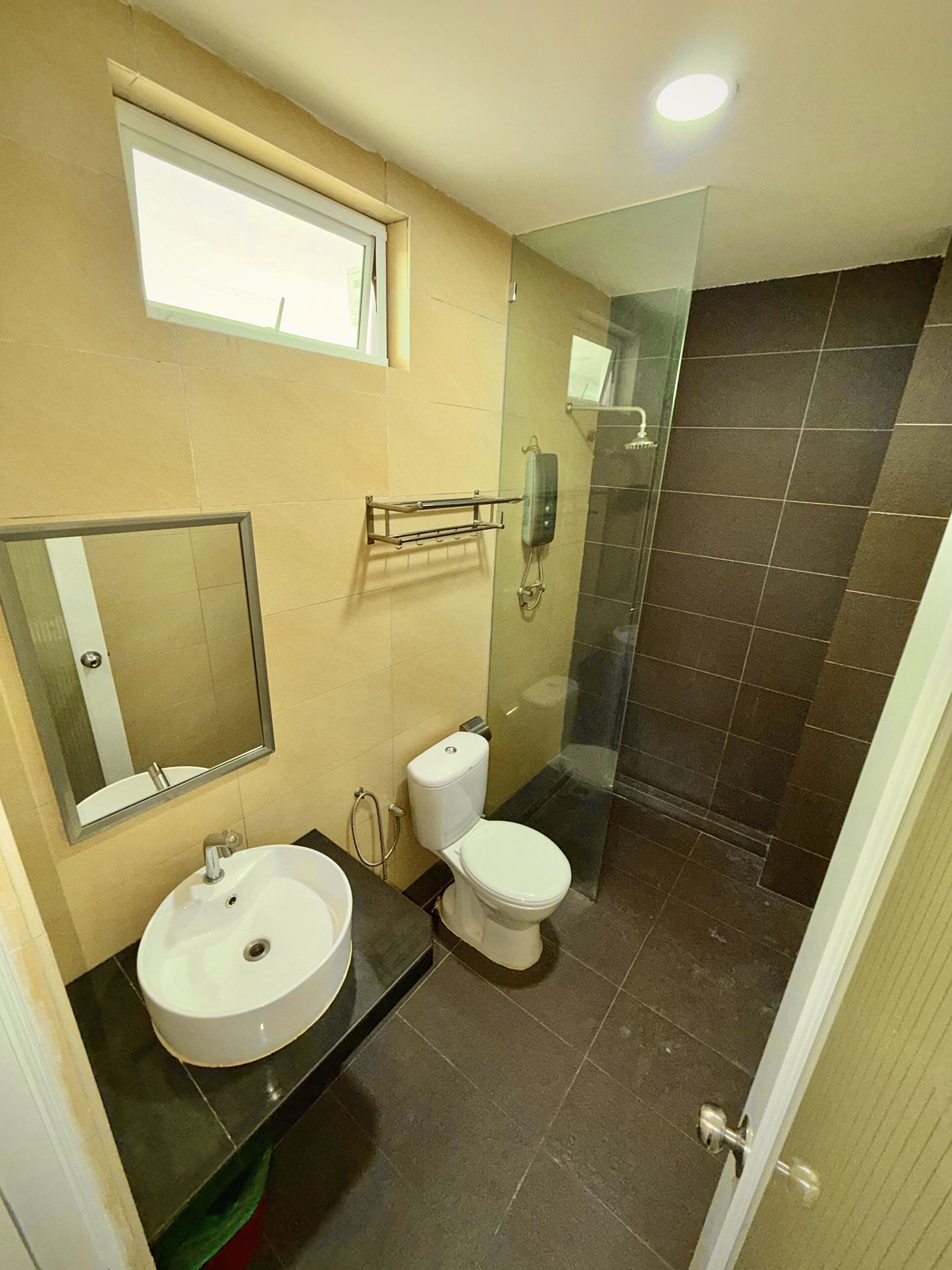 A bathroom with a sink, toilet, and a glass shower enclosure.