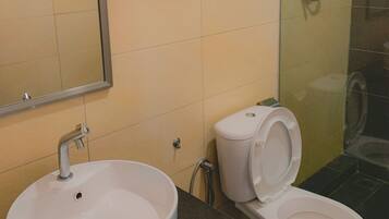 A bathroom with a sink, toilet, and a shower area.