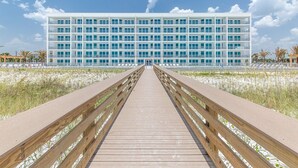 A modern hotel with a long wooden boardwalk leading to the entrance. - Blu 300 ~ Stunning 4BR w/ Gulf Views ~ Free Beach Service (Fort Walton Beach)