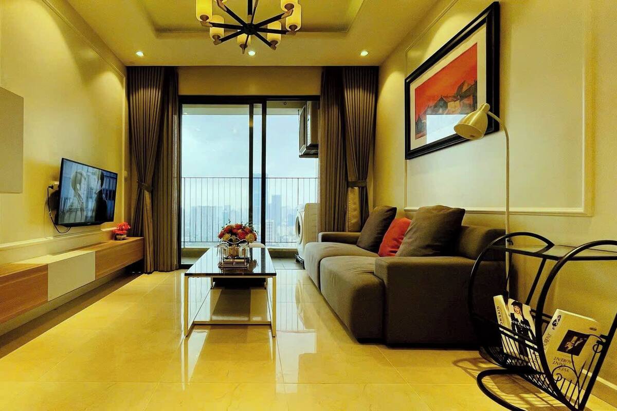 A modern living room with a sofa, a coffee table, a TV, and a bookshelf.