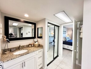 A bathroom with a large mirror, a sink, and a vanity with drawers. - OV 926 Golf Course View Condo - Welcome to Paradise (Fort Pierce)