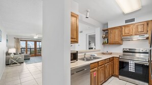 A modern kitchen with wooden cabinets, stainless steel appliances, and a dishwasher. - La Mirage Condo 203 Beachfront Resort Condominiums with Private Boardwalk (Port Aransas)