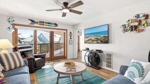 Un salon comprenant un canapé, un fauteuil, une table basse et un ventilateur de plafond.