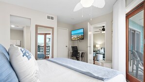 A bedroom with a bed, a TV mounted on the wall, and a balcony with a view.