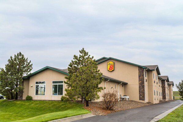 Experience the serene atmosphere of this Super 8 hotel, surrounded by lush greenery and a well-manicured lawn.