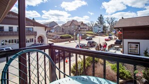 A residential street with houses, a parking lot, and a view from a balcony. - Charming Downtown Two Bedroom w/ Fireplace (New Glarus)