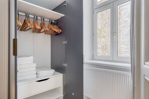 Walk-in closet with shelving unit and hangers, offering ample storage and a view of the surrounding trees.