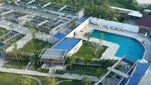 An aerial view of a resort with a swimming pool, a garden area, and a covered outdoor seating area. - Ngoc Thu Palace (Can Tho)