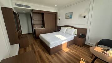 Ein Hotelzimmer mit Bett, Nachttisch und Schreibtisch mit Stuhl.