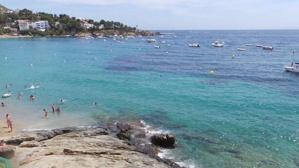 A coastal beach with clear turquoise waters, rocky shoreline, and boats in the distance. - 3381 - SOFIA GROUND FLOOR -B VUE IMPRENABLE, QUARTIER CALME, PARKING (Roses)