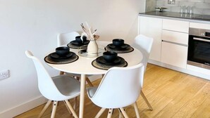 A modern kitchen with white cabinets, a microwave, and an oven.
