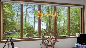 A room with a large window, a telescope, a ship's wheel, and a neon sign reading "Aho Matey!" - Family Luxury: 5BR, Beach, Kayaks, GameRm, Arcade, MovieRm, PingPong, Fire Pit (Saint Leonard)