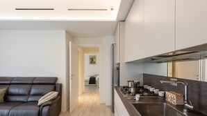 Une cuisine moderne dotée d’une cuisinière intégrée, d’un évier en acier inoxydable et d’un plan de travail agrémenté d’un élément décoratif en forme de boîte.