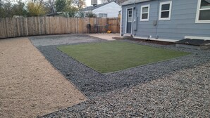 A backyard with artificial turf, gravel, and a wooden fence. - Beautiful, Modern, Quiet, Comfy & Private with a Big Back Yard - 30+ day stays  (Denver)