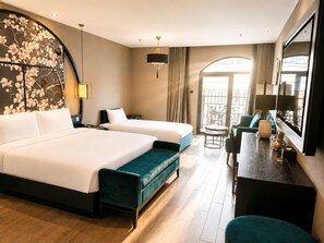 Ett hotellrum med två sängar, en matplats, en balkong och en dekorativ vägg.