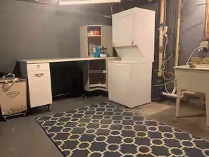 Cozinha compacta com geladeira, micro-ondas e bancada pequena.