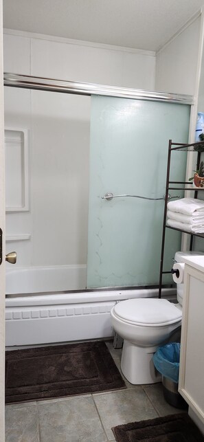 A bathroom with a bathtub, toilet, and a shower area. - Comfortable ranch style cabin with prime location to both Arizona and New Mexico (Luna)