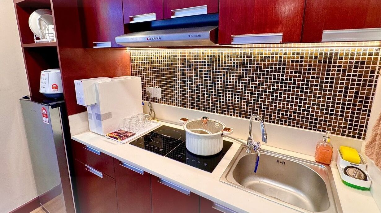 A compact kitchen with a built-in microwave, a stove, and a sink.