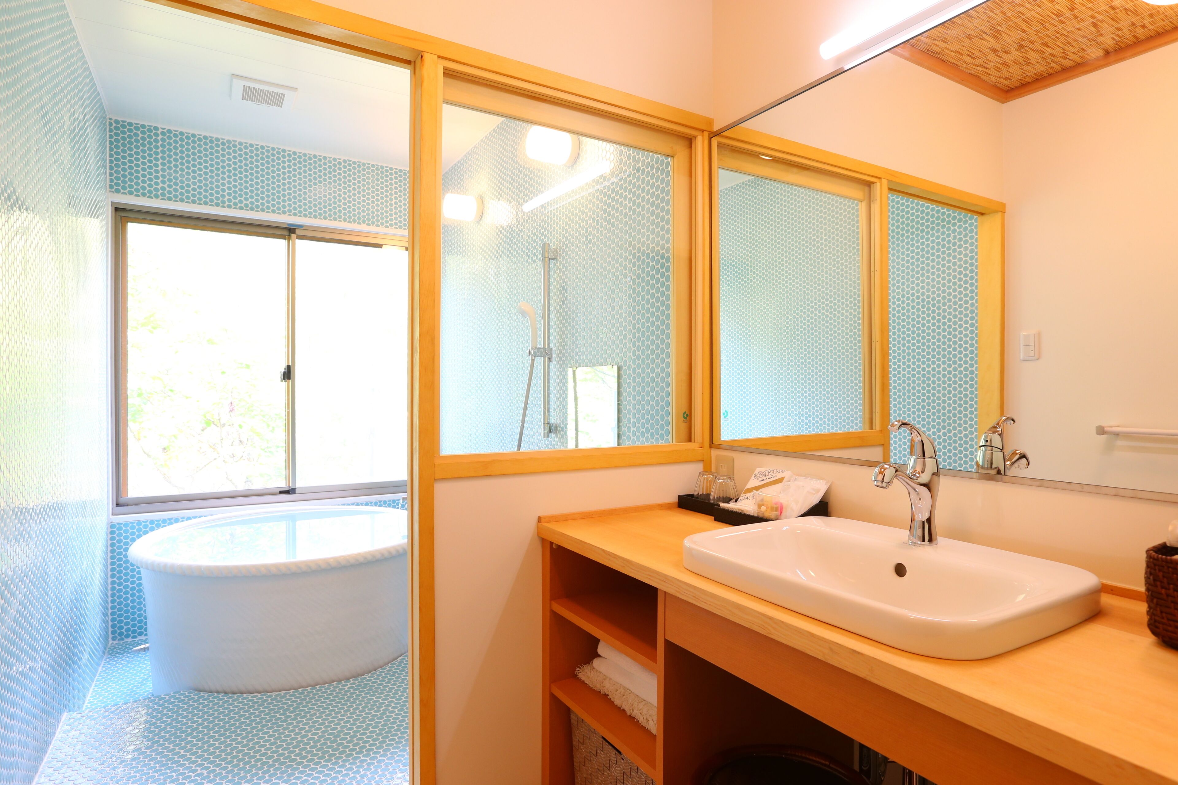 A bathroom with a bathtub, a sink, and a large mirror.