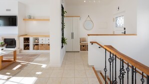 Un salon moderne avec une cheminée, un téléviseur et des étagères en bois.