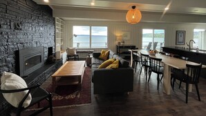 Un salon moderne doté d’une cheminée, d’un coin repas et d’une cuisine.