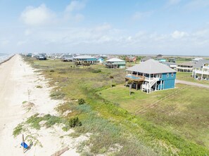 A coastal residential area with houses, a beach, and a clear sky. - Front Row Pool - chilled & heated - hot tub- beachfront  (Bolivar Peninsula)