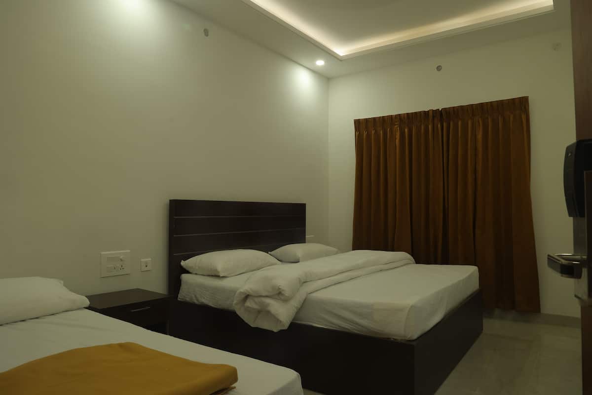 A hotel room with two beds, a brown curtain, and a television.
