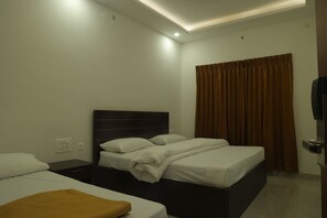 Una habitación de hotel con dos camas, una cortina marrón y un televisor.