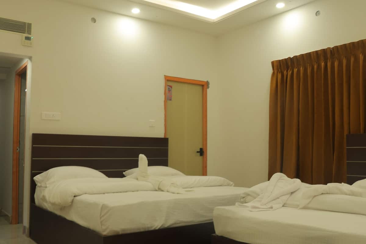 A hotel room with two beds, a ceiling fan, and a door.