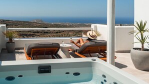 A rooftop terrace with a hot tub, lounge chairs, and potted plants. - Arotron Santorini (Santorini)