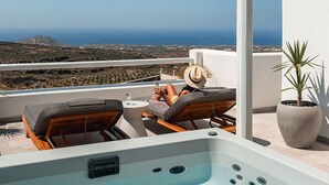 A rooftop pool with a view of the ocean, lounge chairs, and a potted plant. - Arotron Santorini (Santorini)