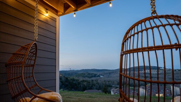 A porch with two wicker chairs and a view of a residential area. - Mt View ★ King bed, Pool, Arcade, Family-friendly ★ 2mi Branson Strip! (Branson)