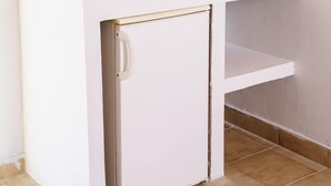 A white kitchenette with a small refrigerator, a countertop, and a tray with cups. - Mayo Rooms (Zakynthos)