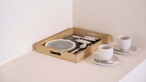 A wooden tray with plates, cups, and cutlery on a table. - Mayo Rooms (Zakynthos)